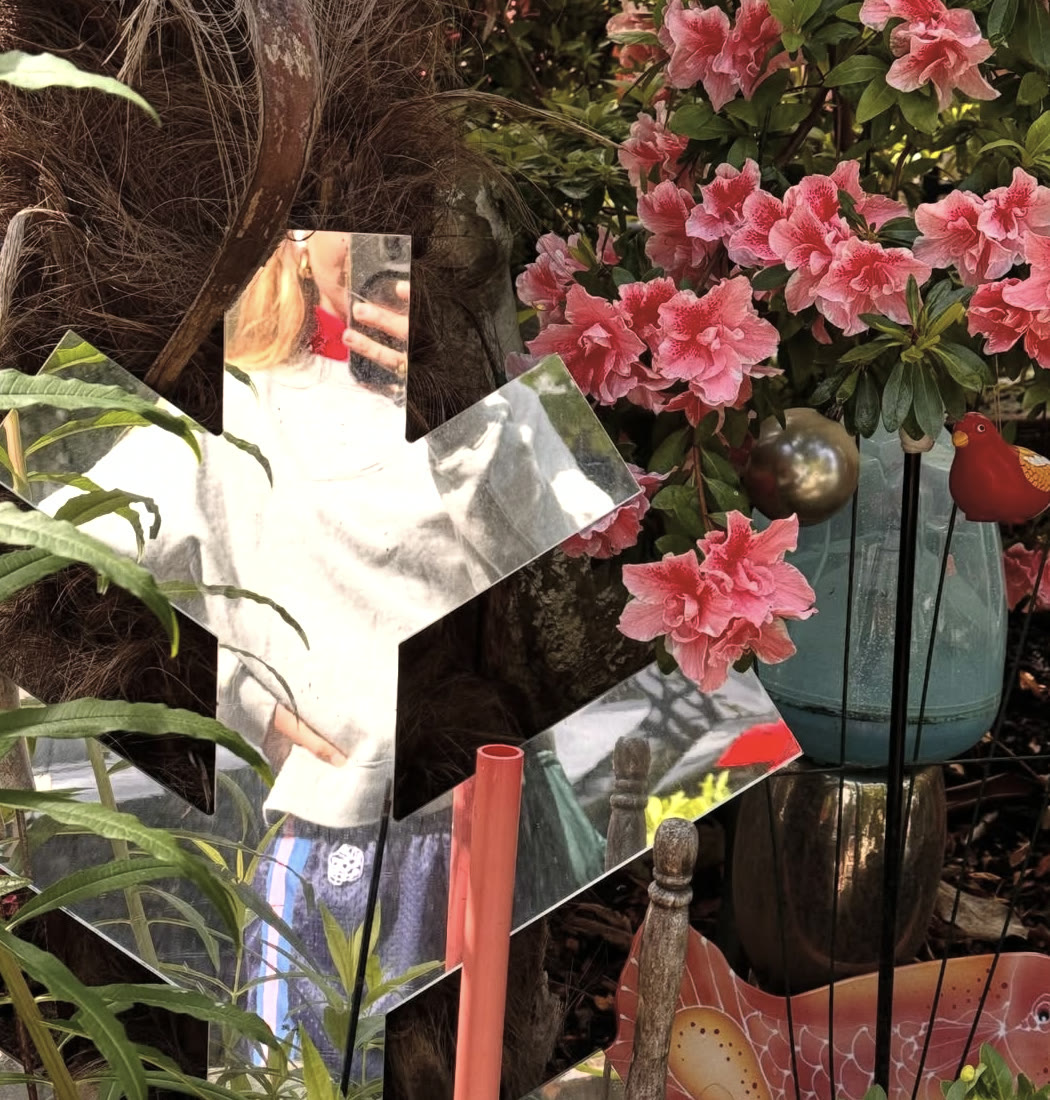 An artful garden filled with flowers and mirrors