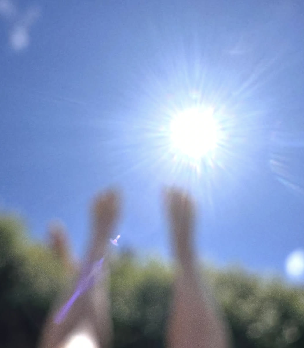 Legs lifted toward a bright blue sky