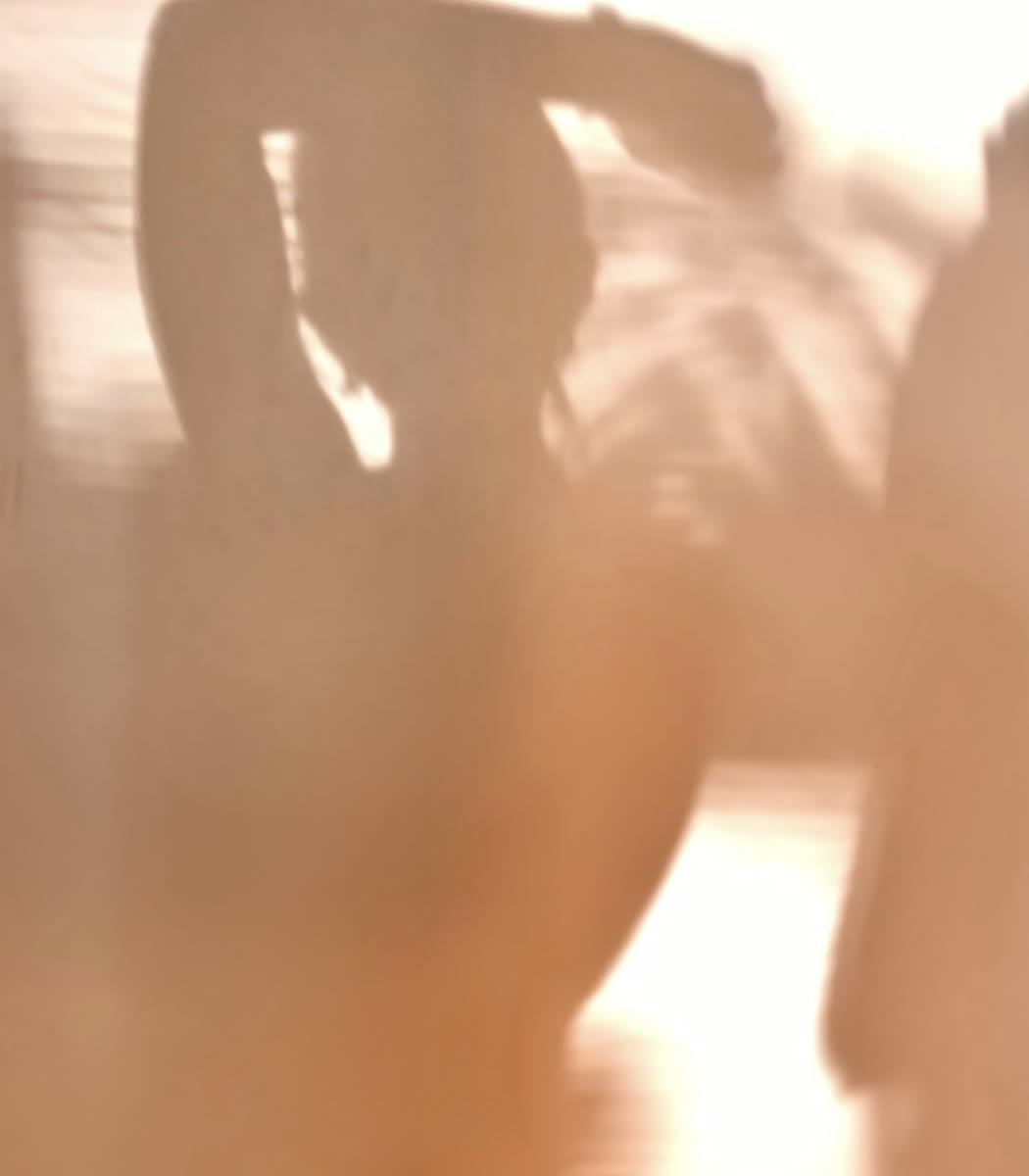 A softly blurred silhouette moving in warm light